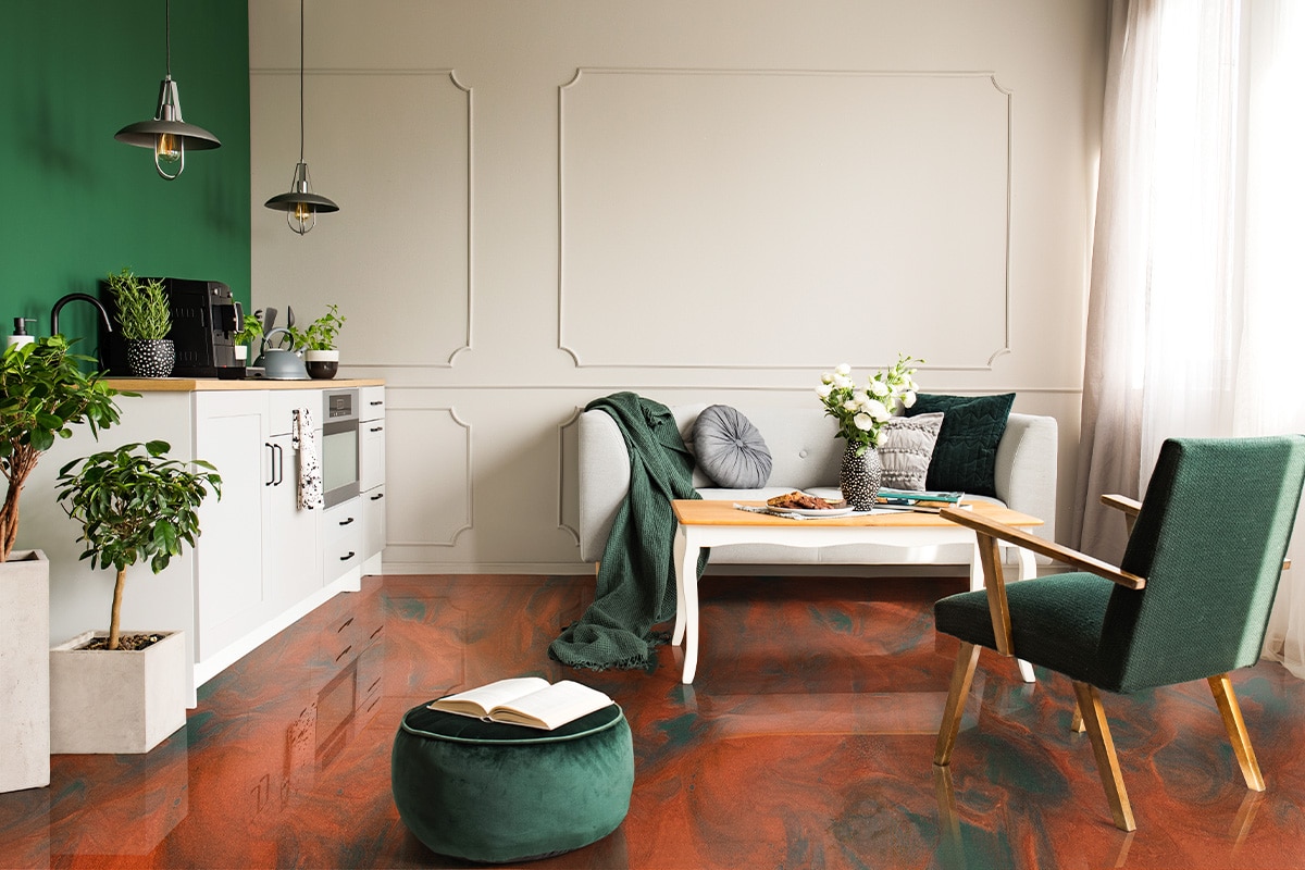Open book on dark green velvet pouf in grey living room and kitchen interior with retro armchair, coffee table and sofa